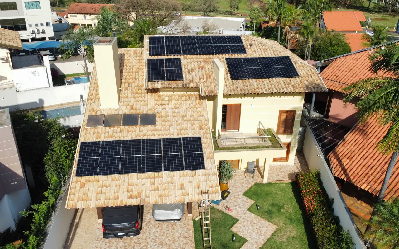 Residência com módulos fotovoltaicos distribuídos em três águas do telhado